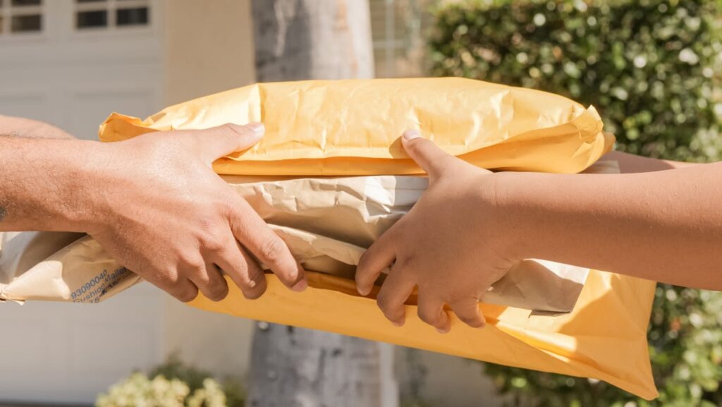 pexels photo 6994138 Close-up of two hands exchanging packages, symbolizing delivery and communication.